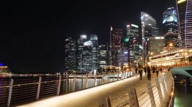 Singapur - 27 Kasım 2017: Pan Esplanade Köprüsü Singapur doğru görüntüleri gökdelenler görünümü ve kalabalık ziyaretçi köprüde geceleri yürüyüş yaptı. 4 k çözünürlükte vurdu