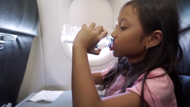 Video Una Linda Niña Bebiendo Una Botella Agua Avión Durante — Vídeo de stock