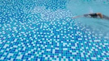 Genç bir adam üzerinde mavi su ve giyiyor Mayo ile havuz yüzme video görüntüleri