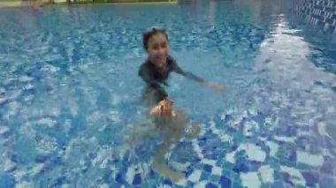 Mutlu genç kadının rahatlatıcı bir lüks otel Yüzme Havuzu mayo giyen süre üzerinde video görüntüleri