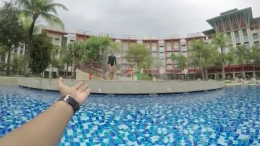 Erkek el video görüntüleri üzerinde lüks otelin havuzunda yüzmeyi kız arkadaşı davet ediyor.