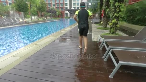 一个小男孩在豪华酒店的游泳池里跑来跳去的视频镜头 在户外拍摄 — 图库视频影像