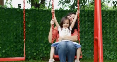 Neşeli genç anne ve kızı parkta, salıncakta oynarken vuruldu 4 k çözünürlük
