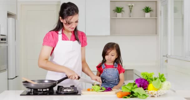 Jonge Moeder Haar Dochter Koken Van Groenten Samen Keuken Thuis — Stockvideo