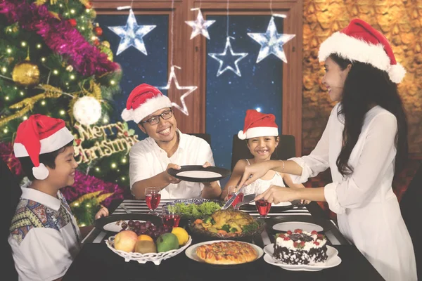 Mujer joven sirviendo a su familia en la cena de Navidad —  Fotos de Stock