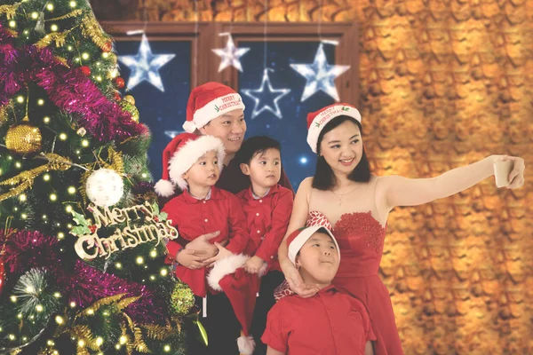 Gelukkige familie neemt foto met kerstboom — Stockfoto