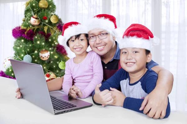 Отец и дети с ноутбуком на Рождество — стоковое фото