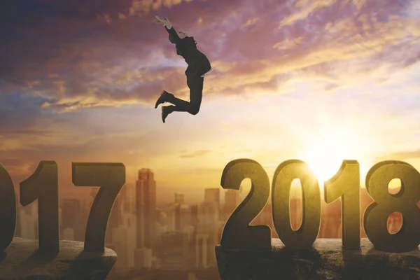 European businessman leaps toward number 2018 — Stock Photo, Image