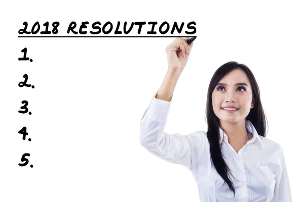 Zakenvrouw schrijven van een lijst resoluties voor 2018 — Stockfoto