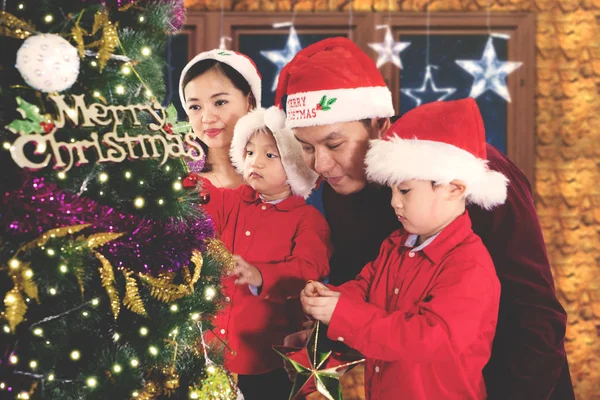 Asiatische Eltern mit Kindern schmücken Weihnachtsbaum — Stockfoto