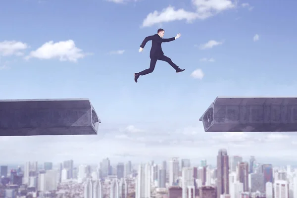 Homem de negócios americano saltando sobre a ponte lacuna — Fotografia de Stock