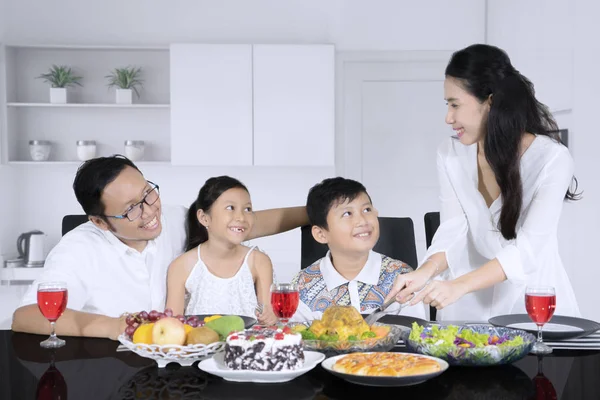 Junge Frau serviert Brathähnchen für ihre Familie — Stockfoto