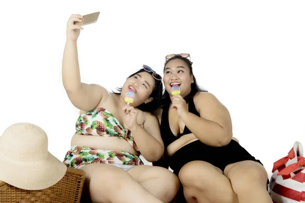 Duas mulheres obesas tirando fotos com sorvete — Fotografia de Stock