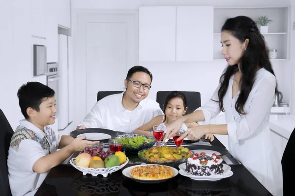 Mujer bonita sirviendo pollo asado para su familia — Foto de Stock