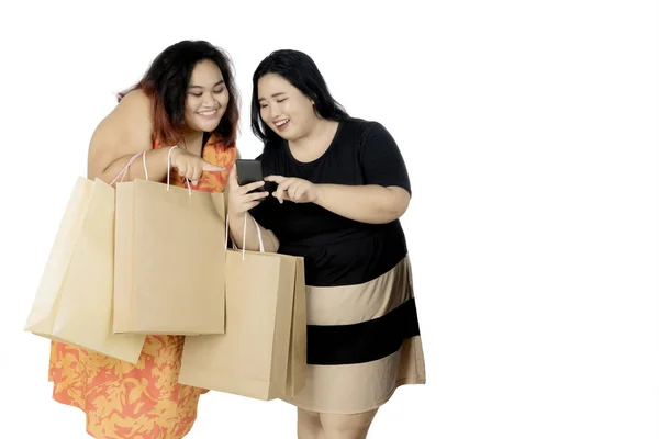 Smartphone ve alışveriş torbaları ile obez kadın — Stok fotoğraf