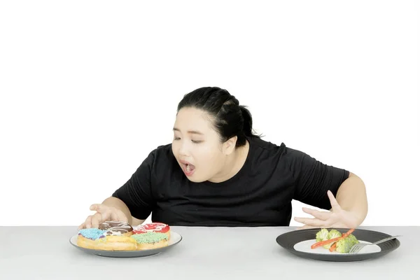 Zwaarlijvige vrouw afwijzing van een salade op studio — Stockfoto