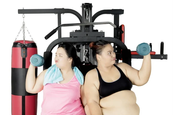Ожиріння жінок, що займаються з гантелі на студії — стокове фото