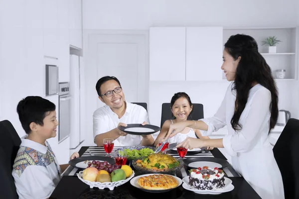 Gelukkige vrouw is het serveren van maaltijden voor haar familie — Stockfoto