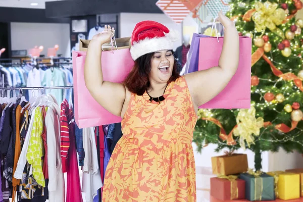 Mujer gorda feliz con regalos de Navidad en el centro comercial — Foto de Stock