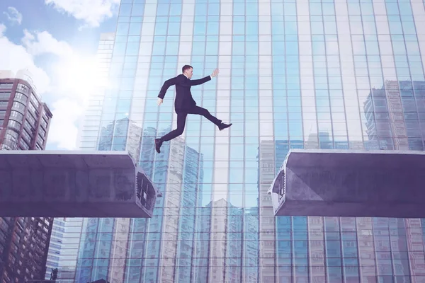 Homem de negócios europeu saltando sobre a ponte — Fotografia de Stock