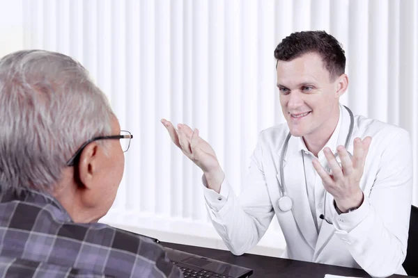 Doctor giving a consultation to elderly patient — Stock Photo, Image