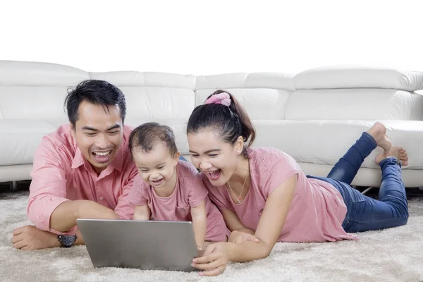 Asijské rodiny pomocí přenosného počítače na koberec — Stock fotografie