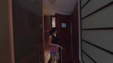 Singapur. 11 Aralık 2017: Marina Mandarin Hotel Singapore adlı bavulu taşırken beş yıldızlı bir otel odasında gelen mutlu genç kadın