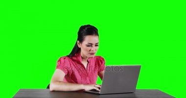 4 k çözünürlüklü yeşil ekran arka planı ile vurdu tablo ve görünüm olsun fikri üzerine bir dizüstü bilgisayar ile çalışan genç bir kadın işçi