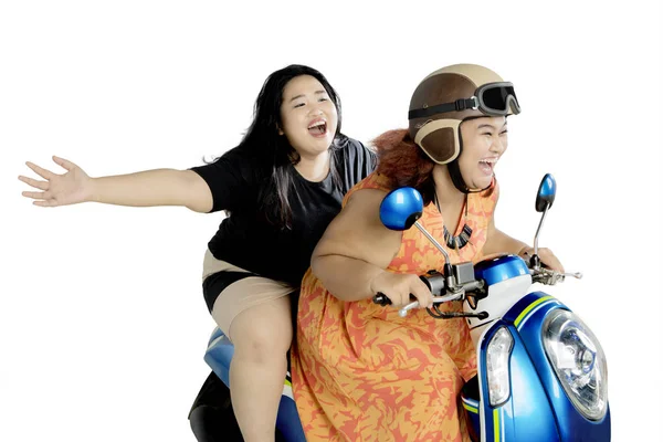 İki mutlu kadın studio bir motosiklet sürme — Stok fotoğraf