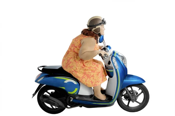 Overweight woman riding a motorbike on studio — Stock Photo, Image