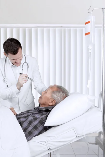 Ophthalmologist checking an elderly patient eyes — Stock Photo, Image