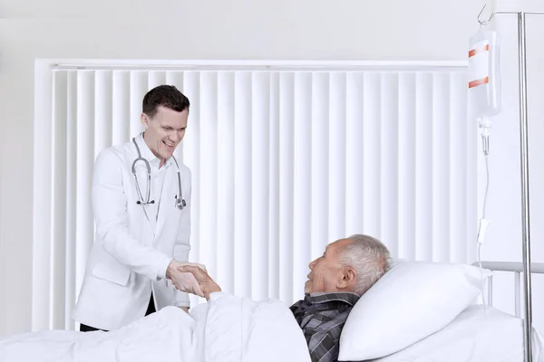 Médico masculino apertando a mão com paciente idoso — Fotografia de Stock