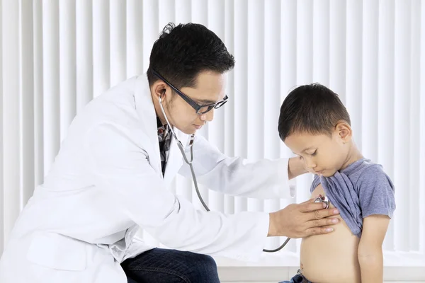 Médico masculino examinando uma criança paciente — Fotografia de Stock