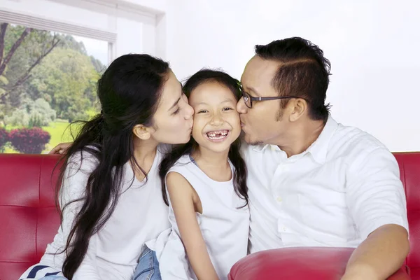 Szczęśliwych rodziców całując ich córka, w domu — Zdjęcie stockowe