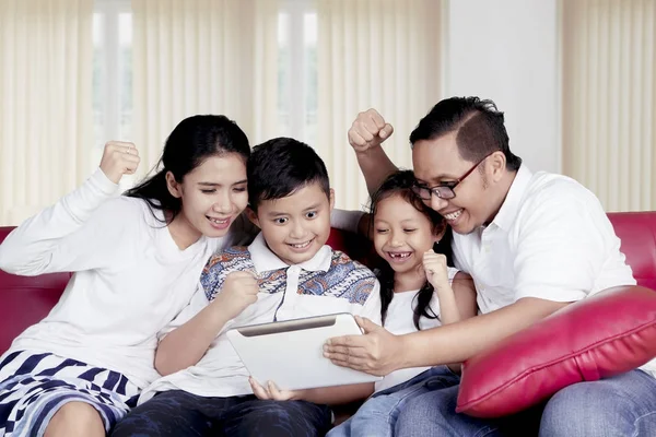 Щаслива сім'я використовує планшет разом вдома — стокове фото