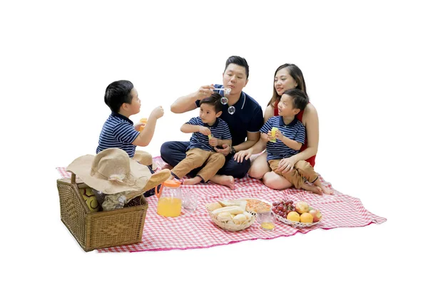Onnellinen perhe picnicking kanssa kupla saippua — kuvapankkivalokuva