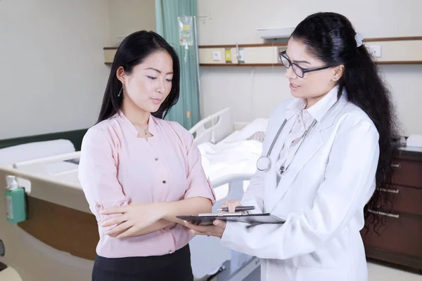 Kvinnliga läkare förklarar diagnos till hennes patient — Stockfoto