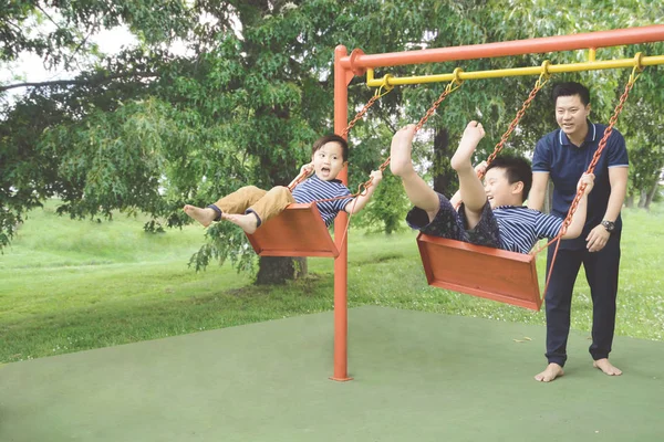 Vater und Kinder spielen mit Schaukeln — Stockfoto