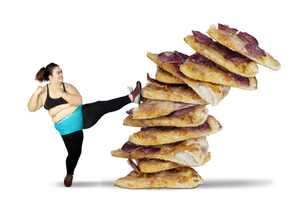Fat woman kicking pile of pizza