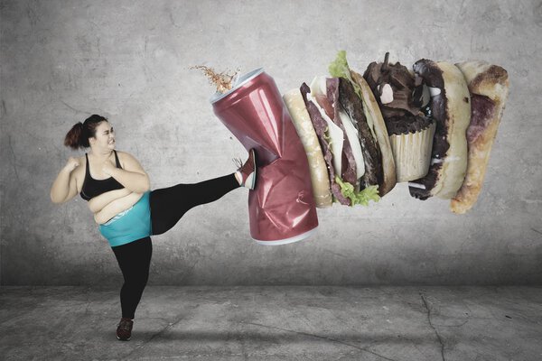 Fat woman kicks soft drink and junk foods