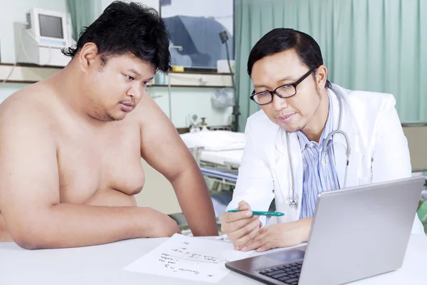 Homem gordo e médico olhando para o resultado médico — Fotografia de Stock