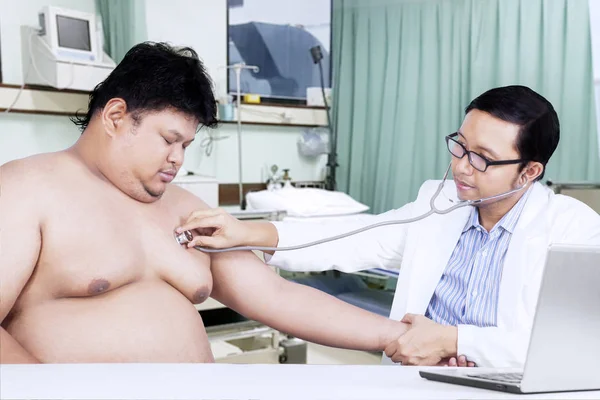 Doktor hastanın kalp atışlarını dinlemek için stetoskop kullanarak — Stok fotoğraf