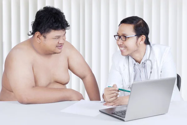 Doctor showing a medical result to his patient — Stock Photo, Image