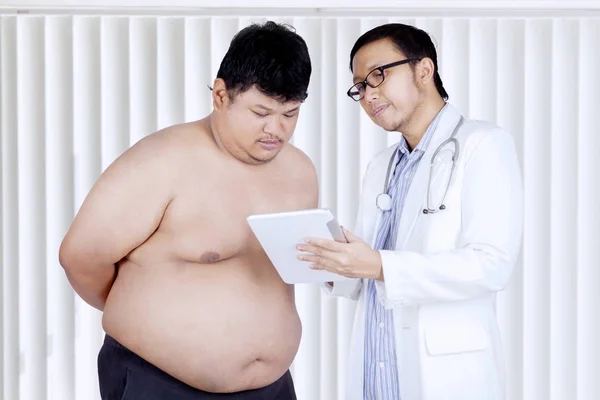 Médico explicando o relatório médico a um paciente — Fotografia de Stock