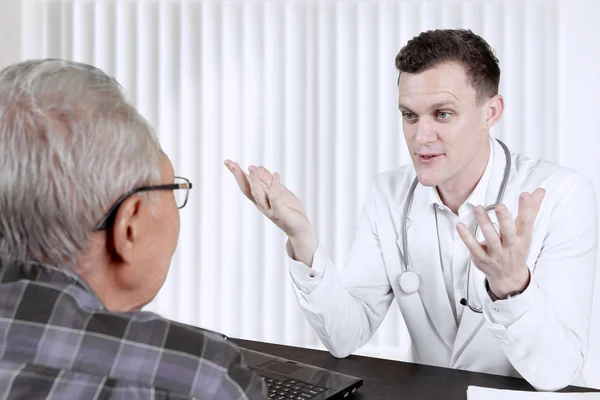 Médecin expliquant le diagnostic à son patient âgé — Photo