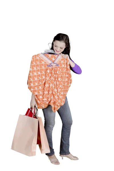 Mulher branca segurando um vestido e sacos de compras — Fotografia de Stock