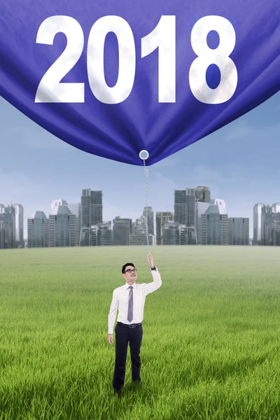 Affärsman dra banner med nummer 2018 — Stockfoto