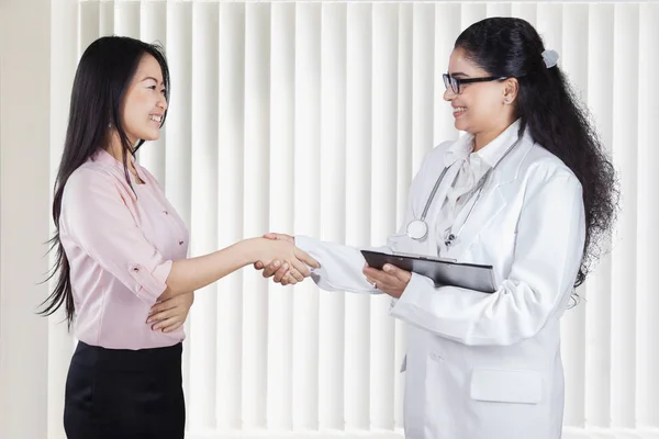 Mulher bonita apertando as mãos com médico — Fotografia de Stock