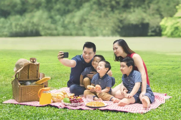 Азиатская семья фотографирует в парке — стоковое фото