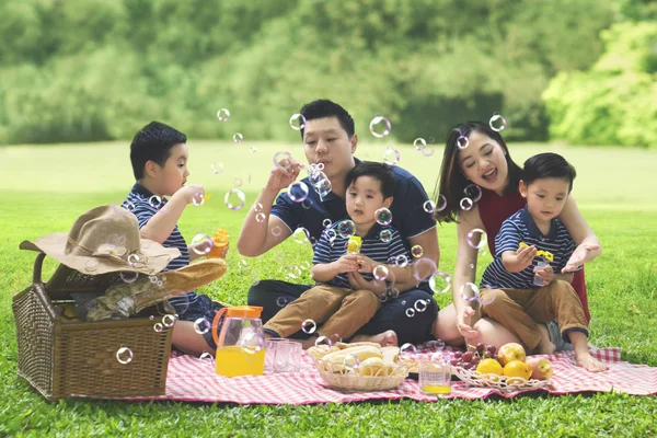 Ασιατικής οικογένειας φυσάει φούσκα σαπούνι στο πάρκο — Φωτογραφία Αρχείου
